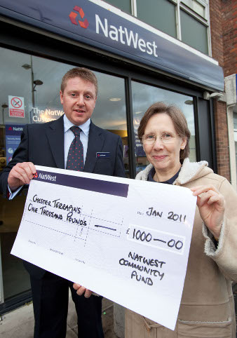 Secretary and Ian Carson (senior bank manager) holding £1000 cheque